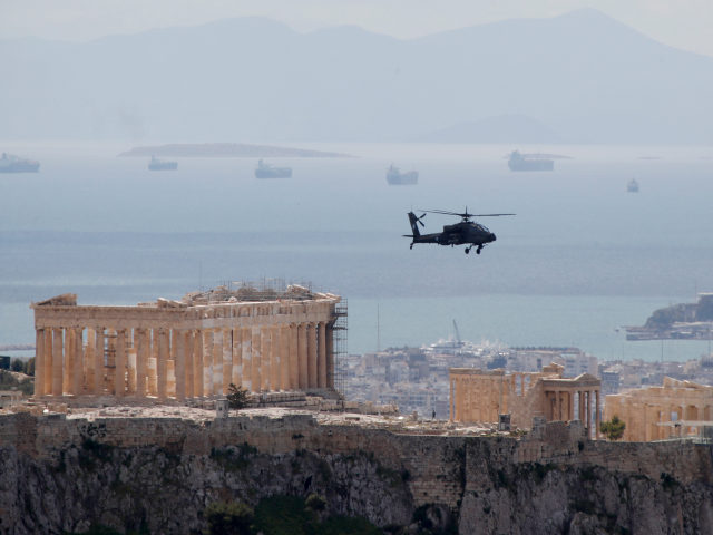 A military helicopter flies over Acropolis hill during a rehearsal in Athens, Thursday, Ma