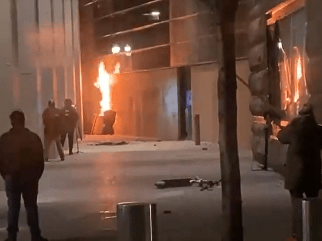 Antifa rioters set boarded-up windows on fire outside the Hatfield Federal Courthouse in Portland, Oregon, on March 11, 2021. (Twitter Screenshot/Jennifer Dowling-KOIN6)