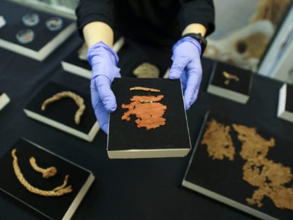 An archaeologist at the Israel Antiquities Authority (IAA) shows a cloth fragment from the