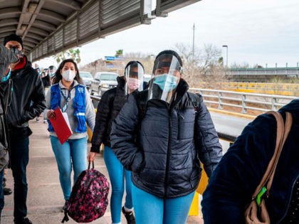 Migrants approach the US border on Gateway International Bridge in Brownsville, Texas on March 2, 2021. - President Biden announced that he was ending the Migrant Protection Protocol (MPP) enacted under President Trump that sent asylum seekers back to Mexico as they awaited their trial dates. (Photo by Sergio FLORES …