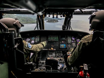 Colombian Air Force pilots fly a blackhawk helicopter over the Gulf of Uraba during a surveillance mission in which also school kits and humanitarian aid were distributed, in Choco department, Colombia, near the border with Panama, on October 14, 2020, amid the new coronavirus pandemic. (Photo by JOAQUIN SARMIENTO / …