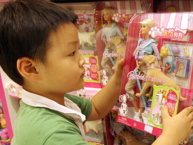 In this file photo, a Chinese boy holds a "Barbie and Tanner" toy made by US toy giant Mattel, which is still for sale in China despite being recalled in the US, at a department store in Shanghai, 15 August 2007. (Mark Ralston/AFP via Getty Images)