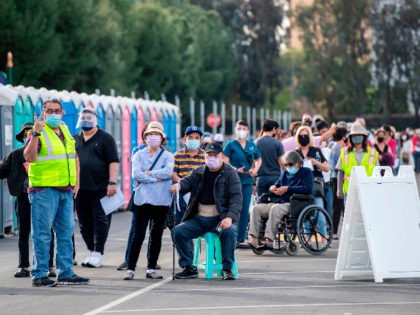 People wait in line in a Disneyland parking lot to receive Covid-19 vaccines on the openin