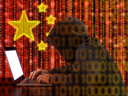 Hacker in a dark hoody sitting in front of a notebook with digital Chinese flag background and binary streams cybersecurity concept