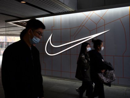 People walk past a Nike store in Beijing on March 25, 2021. (Photo by GREG BAKER / AFP) (P