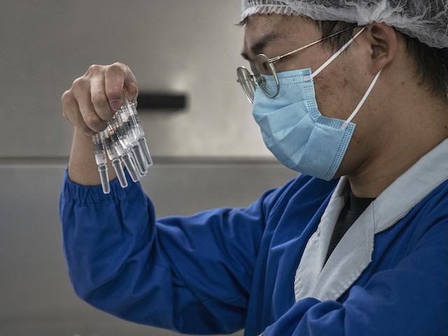 A worker checks syringes of the potential vaccine CoronaVac on the production line at Sinovac Biotech where the company is producing their potential COVID-19 vaccine CoronaVac on September 24, 2020 during a media tour in Beijing, China. (Kevin Frayer/Getty Images)