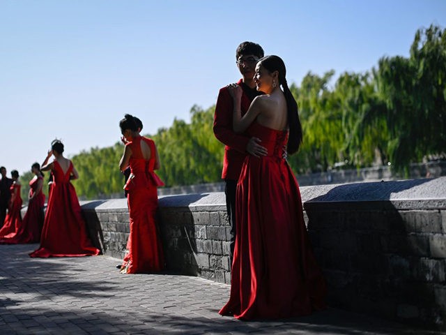 TOPSHOT - Couples pose for wedding pictures near the Forbidden City in Beijing on October 21, 2020. (Photo by WANG Zhao / AFP) (Photo by WANG ZHAO/AFP via Getty Images)