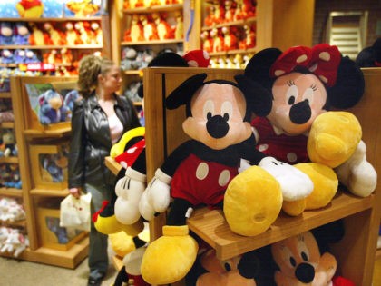 In this file photo, a woman shops for items behind Mickey and Minnie Mouse stuffed toys in a Disney Store March 15, 2004 in Chicago. (Tim Boyle/Getty Images)