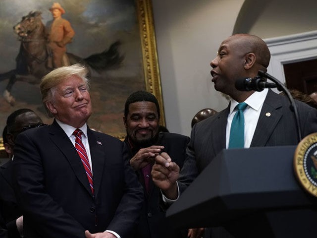 WASHINGTON, DC - DECEMBER 12: U.S. President Donald Trump (C) reacts as Sen. Tim Scott (R-SC) (R) praises him as Secretary of Housing and Urban Development Secretary Ben Carson (L) looks on during a signing event of an executive order to establish the White House Opportunity and Revitalization Council look …