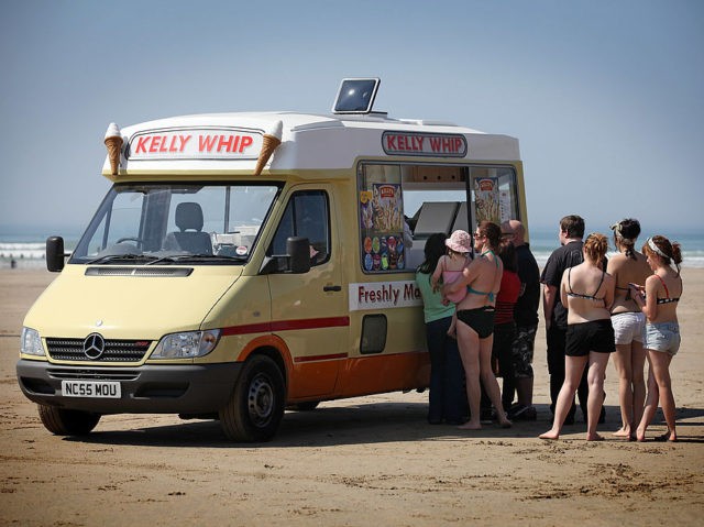 PADSTOW, UNITED KINGDOM - APRIL 21: People queue for an ice-cream van as they enjoy the f