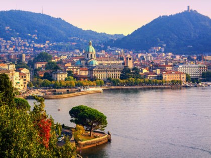 Como city historical town center and Alps mountains on Lake Como, Italy, in warm sunset li