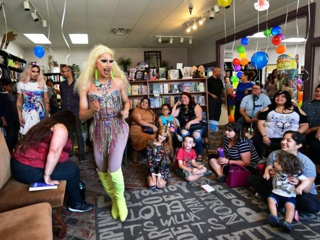 Drag queens Athena Kills (C) and Scalene Onixxx arrive to awaiting adults and children for Drag Queen Story Hour at Cellar Door Books in Riverside, California on June 22, 2019. - Athena and Scalene, their long blonde hair flowing down to their sequined leotards and rainbow dresses, are reading to …