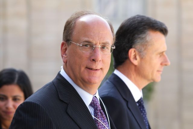 Chairman and CEO of BlackRock, Larry Fink (L) leaves after a meeting about climate action