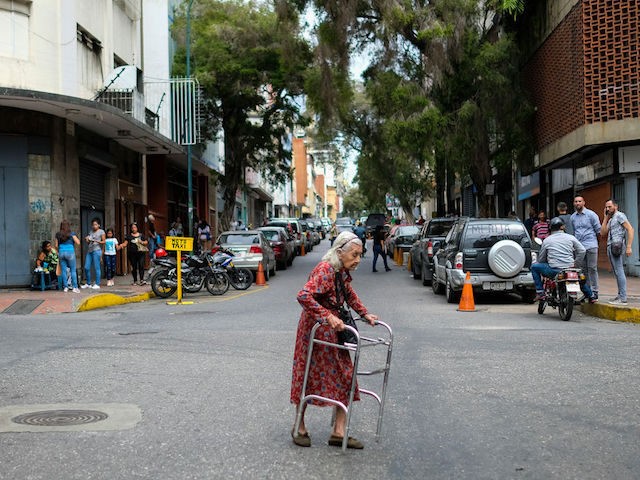 An elderly woman crosses a street in Caracas on July 22, 2019. - Venezuela is wracked by an economic crisis after five years of crippling recession in which its population has faced many hardships such as a shortage of basic necessities and failing public services. (Photo by Matias Delacroix / …