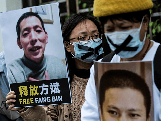 A pro-democracy activist (C) from HK Alliance holds a placard of missing citizen journalist Fang Bin, as she protests outside the Chinese liaison office in Hong Kong on February 19, 2020, in protest against Beijings detention of prominent anti-corruption activist Xu Zhiyong. - Police in China have arrested Xu Zhiyong, a prominent anti-corruption activist who had been criticising President Xi Jinpings handling of the COVID-19 coronavirus. (Photo by ISAAC LAWRENCE / AFP) (Photo by ISAAC LAWRENCE/AFP via Getty Images)