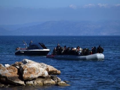 Migrants are escorted upon their arrival on an inflatable boat at Lesbos island where loc