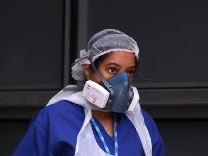 A nurse wears a protective face mask as she walks outside The Royal London Hospital in eas