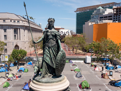 An aerial view shows a statue of Eureka, part of the Pioneer Monument, standinb above squares painted on the ground to encourage homeless people to keep to social distancing at a city-sanctioned homeless encampment across from City Hall in San Francisco, California, on May 22, 2020, amid the novel coronavirus …