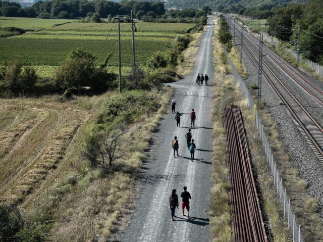 Migrants walk along rail tracks near Idomeni at the border between Greece and North Macedonia on July 16, 2020. - Four years after the evacuation of the Idomeni camp, many refugees and immigrants choose the same route again, trying to leave Greece and find themselves in other European countries. Many …