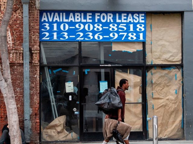 A homeless person walks by a closed business with a sign reading "For Lease" in Santa Monica, California, on July 28, 2020, amid the coronavirus pandemic. (Photo by VALERIE MACON / AFP) (Photo by VALERIE MACON/AFP via Getty Images)