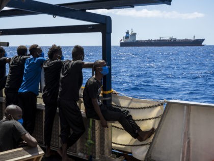 Migrants onboard the Sea-Watch 4 civil sea rescue ship watch towards the oil tanker Maersk Etienne off the coast of Malta on August 27, 2020. - Since the Maersk oil tanker picked up a group of 27 migrants at the beginning of August 2020 in the Mediterranean, the vessel has …