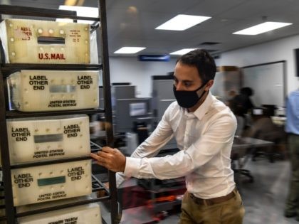Electoral workers are seen during the vote-by-mail ballot scanning process at the Miami-Da