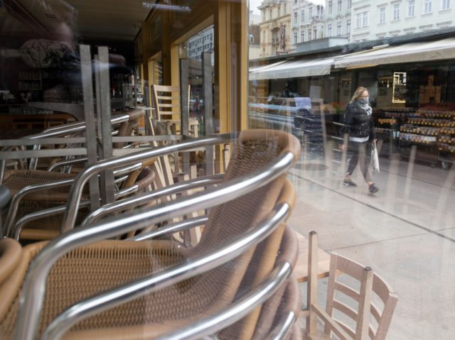 A woman walks past a closed restaurant at the deserted Naschmarkt market in Vienna, Austria, on November 17, 2020. - Austria has entered its second lockdown with the new anti-coronavirus restrictions, shutting schools and shops until December 6, 2020 to get spiraling numbers of infections under control and urging Austrians …