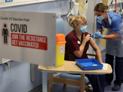 EDINBURGH, SCOTLAND - DECEMBER 08: Deputy charge nurse, Katie McIntosh administers the first of two Pfizer/BioNTech Covid-19 vaccine jabs to Clinical Nurse Manager, Fiona Churchill at the Western General Hospital on the first day of the largest immunisation programme in the UK's history on December 8, 2020 in Edinburgh, Scotland. …