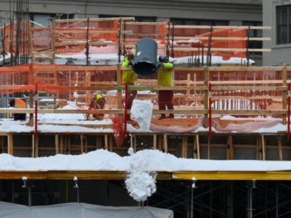 Construction workers free a building construction site of snow in the Brooklyn Borough of New York on February 2, 2021. - A huge snowstorm has brought chaos to the United States' east coast, shuttering airports, closing schools and forcing the postponement of coronavirus vaccinations into Tuesday morning as New York …