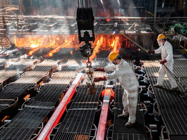 Workers make iron bars in a steel factory in Lianyungang, in China's eastern Jiangsu province on February 12, 2021, the first day of the Lunar New Year. (Photo by - / AFP) / China OUT (Photo by -/AFP via Getty Images)