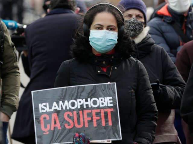 A woman holds a placard reading "enough of islamophobia" as protesters demonstrate against a bill dubbed as "anti-separatism", in Paris on February 14, 2021. - French lawmakers a few weeks ago began debating a controversial bill against what the interior minister described as the "disease" of Islamist extremism eating away …