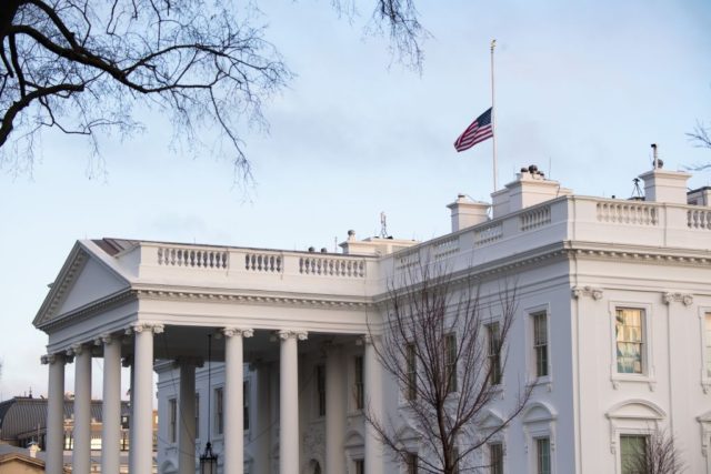 The American flag is seen at half staff over the White House in Washington, DC, February 2