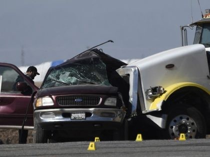 Investigators look over the scene of a crash between an SUV and a semi-truck full of gravel near Holtville, California on March 2, 2021. - At least 13 people were killed in southern California on Tuesday when a vehicle packed with passengers including minors collided with a large truck close …