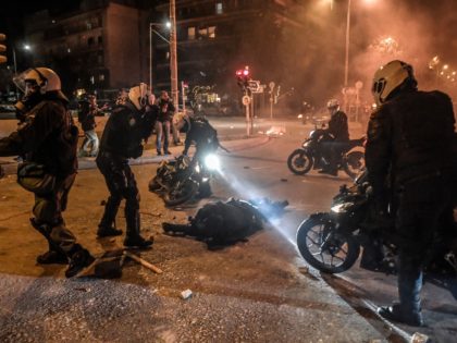 Motorised police arrive to tend to their injuried colleague during a demonstration against police violence in an Athens suburb on March 9, 2021. - Greek police said an officer was seriously injured in the head as clashes broke out March 9 evening at a protest of some 5,000 people in …