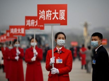 Attendants wait in Tiananmen Square to lead delegates back to their buses after the closin