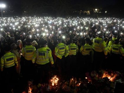 Police officers form a cordon as well-wishers turn on their phone torches as they gather at a band-stand where a planned vigil in honour of murder victim Sarah Everard was cancelled after police outlawed it due to Covid-19 restrictions, on Clapham Common, south London on March 13, 2021, - The …