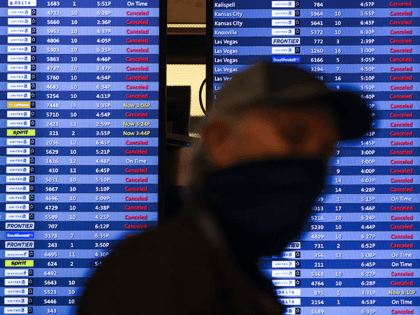 A man walks past a display board showing mostly canceled flights at Denver International Airport on March 13, 2021 in Denver, Colorado. More than 1800 flights into and out of Denver have been canceled this weekend as a winter storm is expected to bring two to four feet of snow …