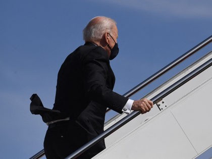 US President Joe Biden continues up the steps after tripping while boarding Air Force One