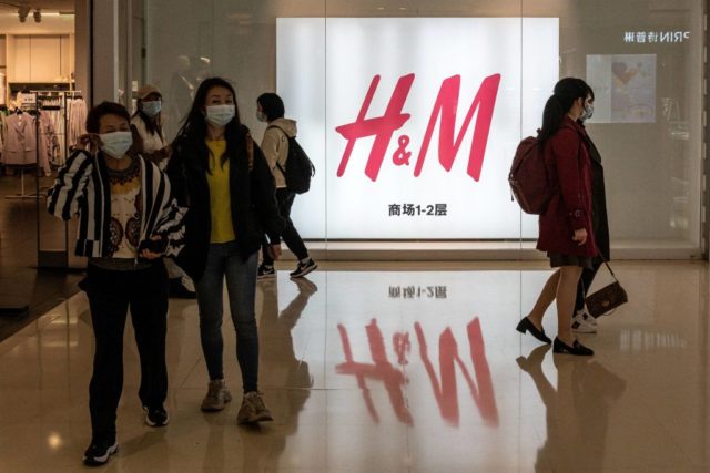 People walk out from a store of Swedish clothing giant H&M in Beijing on March 25, 2021. (Photo by NICOLAS ASFOURI / AFP) (Photo by NICOLAS ASFOURI/AFP via Getty Images)