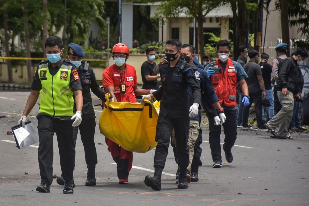 Indonesian police carry a bag with the remains of a suspected suicide bomber after an explosion outside a church in Makassar on March 28, 2021. (INDRA ABRIYANTO/AFP via Getty)
