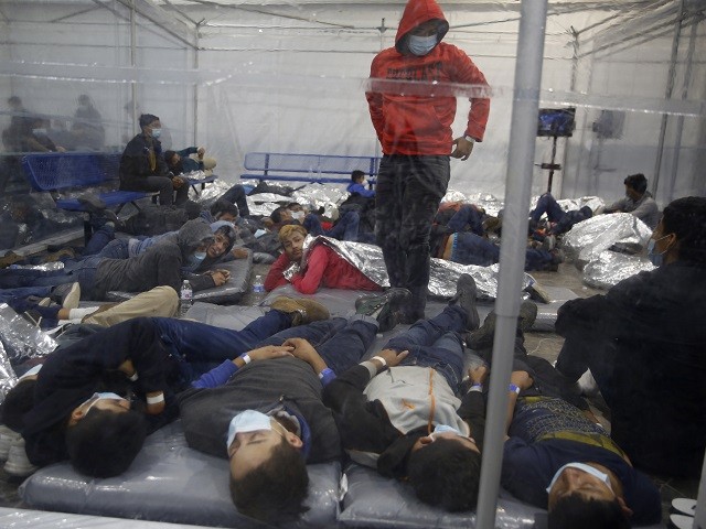 Young children lie inside a pod at the Department of Homeland Security holding facility run by the Customs and Border Patrol (CBP) on March 30, 2021 in Donna, Texas. The Donna location is the main detention center for unaccompanied children coming across the U.S. border in the Rio Grande Valley. The children are housed by the hundreds in eight pods that are about 3,200 square feet in size. Many of the pods had more than 500 children in them. The youngest of the unaccompanied minors are kept separate from the rest of the detainees. The Biden administration has just allowed journalists inside its main detention facility at the border for migrant children. It is an overcrowded tent structure where more than 4,000 kids and families are kept in pods, with the youngest kept in a large play pen with mats on the floor for sleeping. (Photo by Dario Lopez-Mills - Pool/Getty Images)