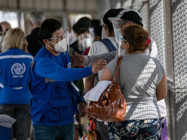 MATAMOROS, MEXICO - FEBRUARY 25: A UN International Organization for Migration staffer congratulates immigrants at the U.S.-Mexico border as a group of at least 25 asylum seekers were allowed to travel from a migrant camp in Mexico into the United States on February 25, 2021 in Matamoros, Mexico. The group …