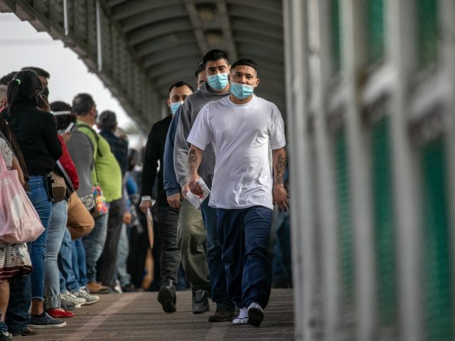 MATAMOROS, MEXICO - FEBRUARY 25: Mexican deportees walk across a U.S.-Mexico border bridge