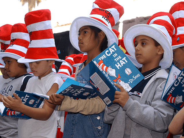 Children read from "The Cat in the Hat" book at a ceremony honoring the late children's book author Dr. Seuss (Theodore Geisel) with a star on the Hollywood Walk of Fame on March 11, 2004 in Hollywood , California. (Photo by Vince Bucci/Getty Images)
