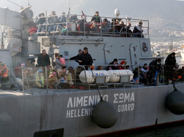 Migrants and refugees arrive aboard a Hellenic coast guard ship at the port of Lesbos isla