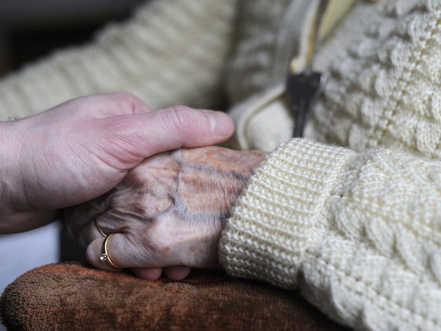 In this file photo, a woman, suffering from Alzheimer's disease, holds the hand of a relative on March 18, 2011 in a retirement house in Angervilliers, eastern France. (Sebastien Bozon/AFP via Getty Images)