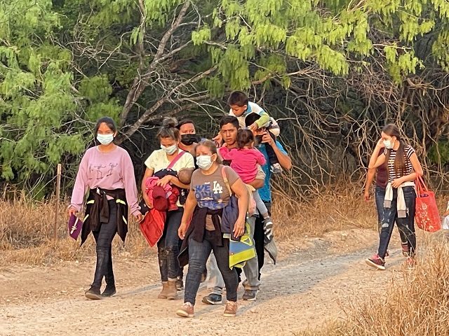 A group of migrant families search for a Border Patrol agent after crossing the Rio Grande