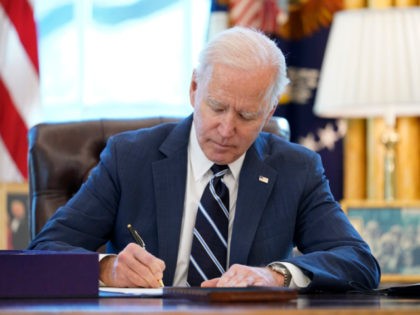 President Joe Biden signs the American Rescue Plan, a coronavirus relief package, in the O