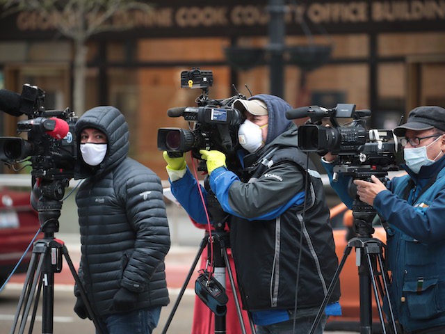 In this file photo, Journalist wearing masks document a protest where demonstrators were calling on the governor to suspend rent and mortgage payments to help those who have lost their income due to the coronavirus on April 30, 2020 in Chicago, Illinois. On May 1, the state of Illinois will …
