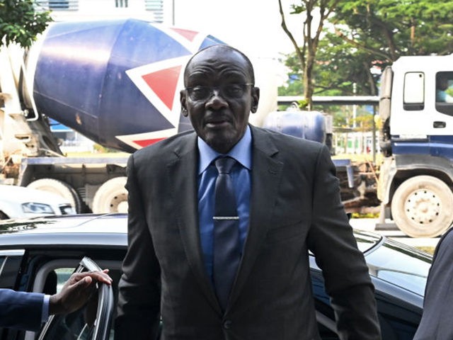 Zimbabwe's Vice President Kembo Mohadi (C) arrives at the Singapore Casket building in Sin